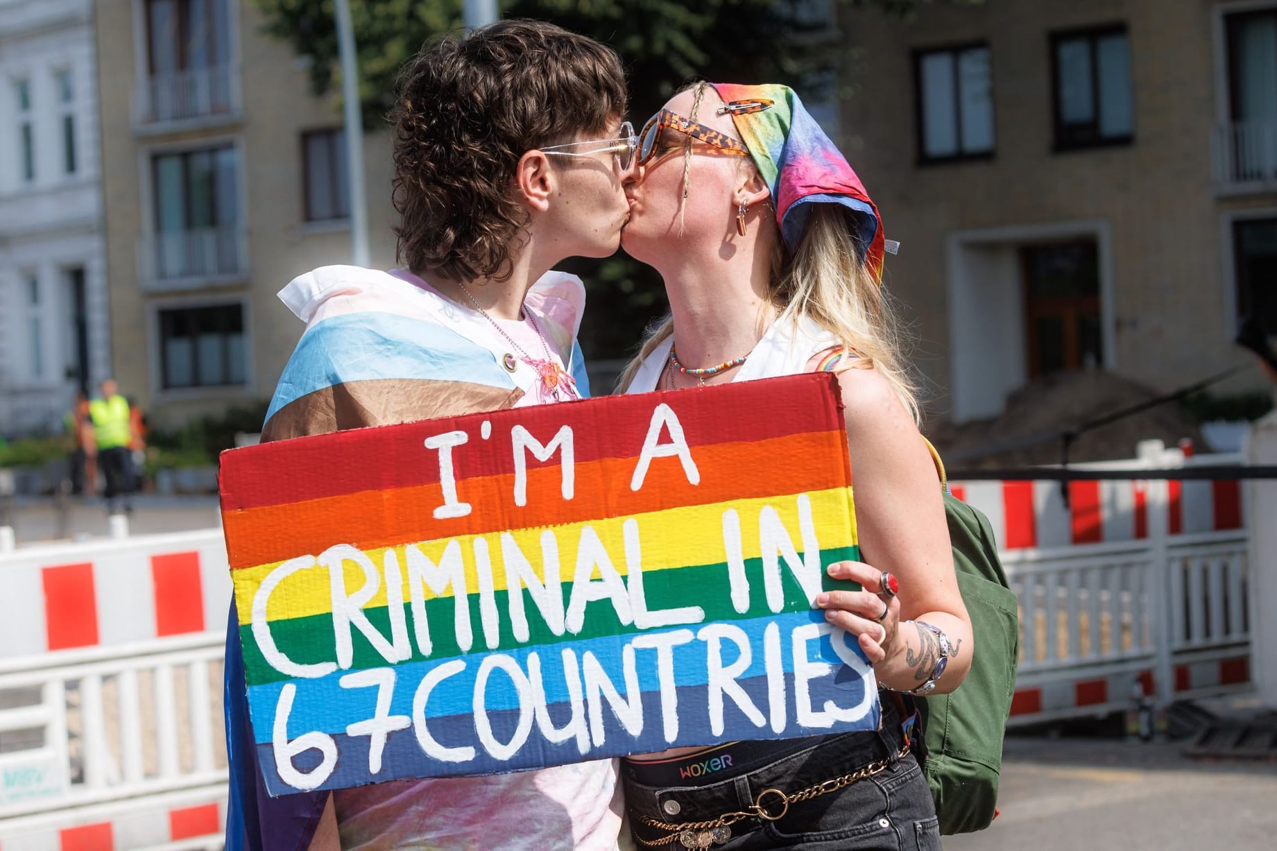 Zwei Frauen halten auf der Demonstration zum Christopher Street Day (CSD) ein Schild mit der Aufschrift "I am a criminal in 67 countries."