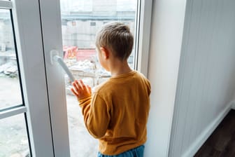 Junge schaut aus einem Fenster (Symbolfoto): In Gelsenkirchen endet die Suche nach einem vermissten Dreijährigen am Wochenende überraschend.