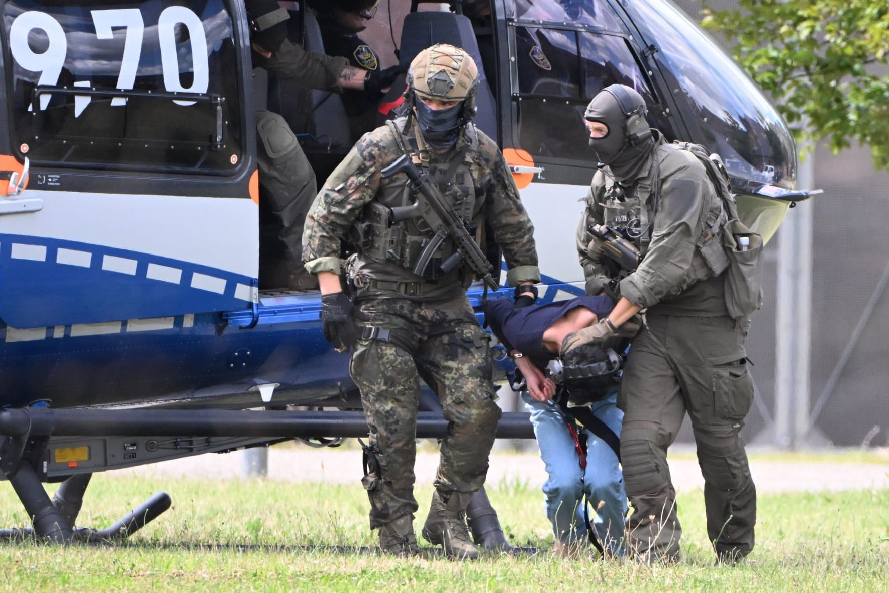 Baden-Württemberg, Karlsruhe: Der mutmaßliche Täter des Messerangriffs von Solingen wird von einem Hubschrauber zu einer Wagenkolonne geführt.