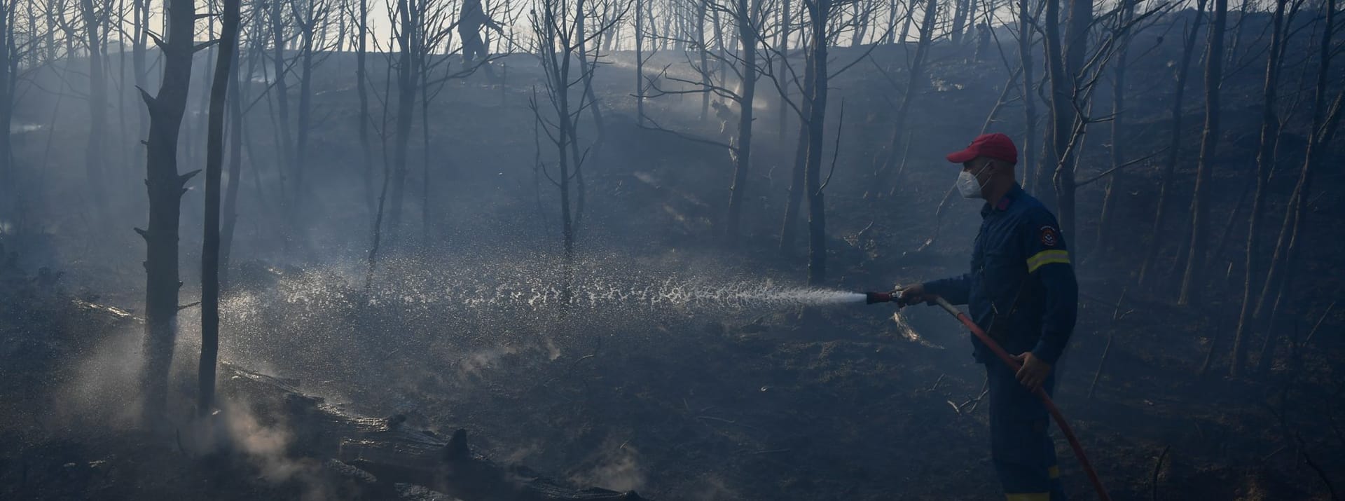 Feuerwehrleute sind bei Löscharbeiten im Einsatz in der Nähe von Penteli, nordöstlich von Athen.