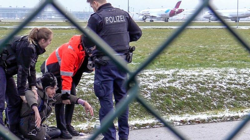 Zwei Beamte der Bundespolizei und ein Sicherheitsmitarbeiter stehen am 8.12.2022 mit einem sichergestellten Bolzenschneider an einem Zaun am BER-Flughafen. Aktivisten der Klimagruppe Letzte Generation hatten versucht auf das Rollfeld zu gelangen