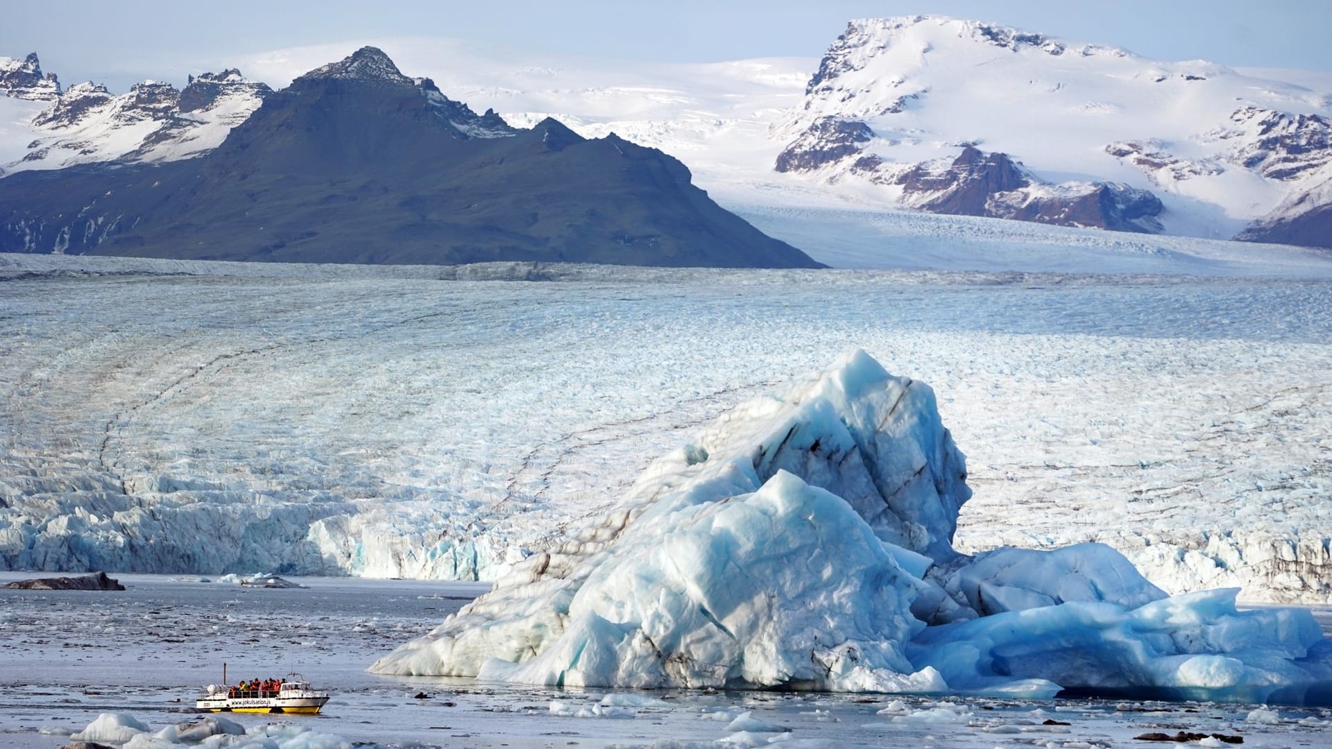 Touristenattraktion: Ein Boot mit Urlaubern fährt an einem Eisberg in der Gletscherlagune Jökulsarlon im Süden des Landes vorbei.