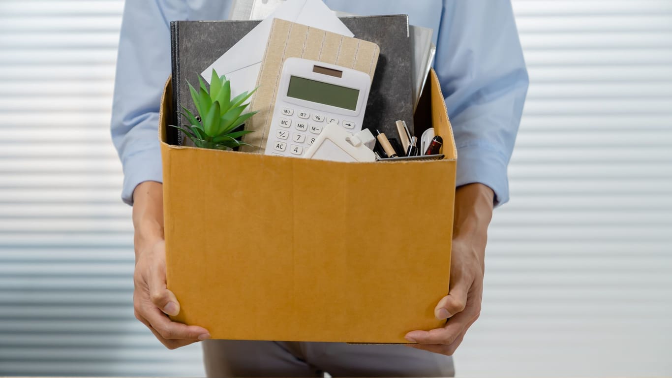 Angestellter packt seine Sachen und verlässt das Büro