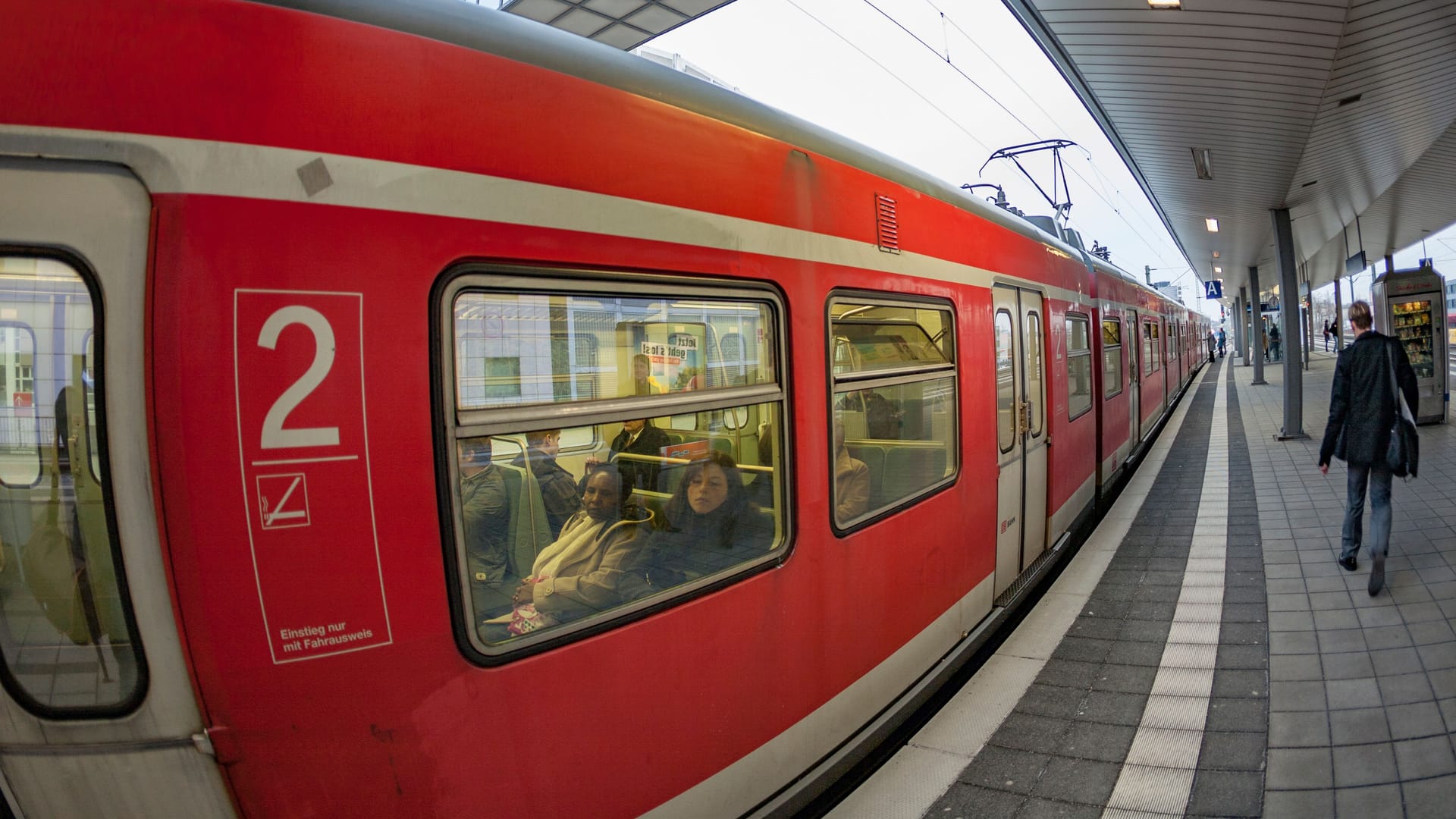 train enters the train station Messe in Frankfurt with view to skyline