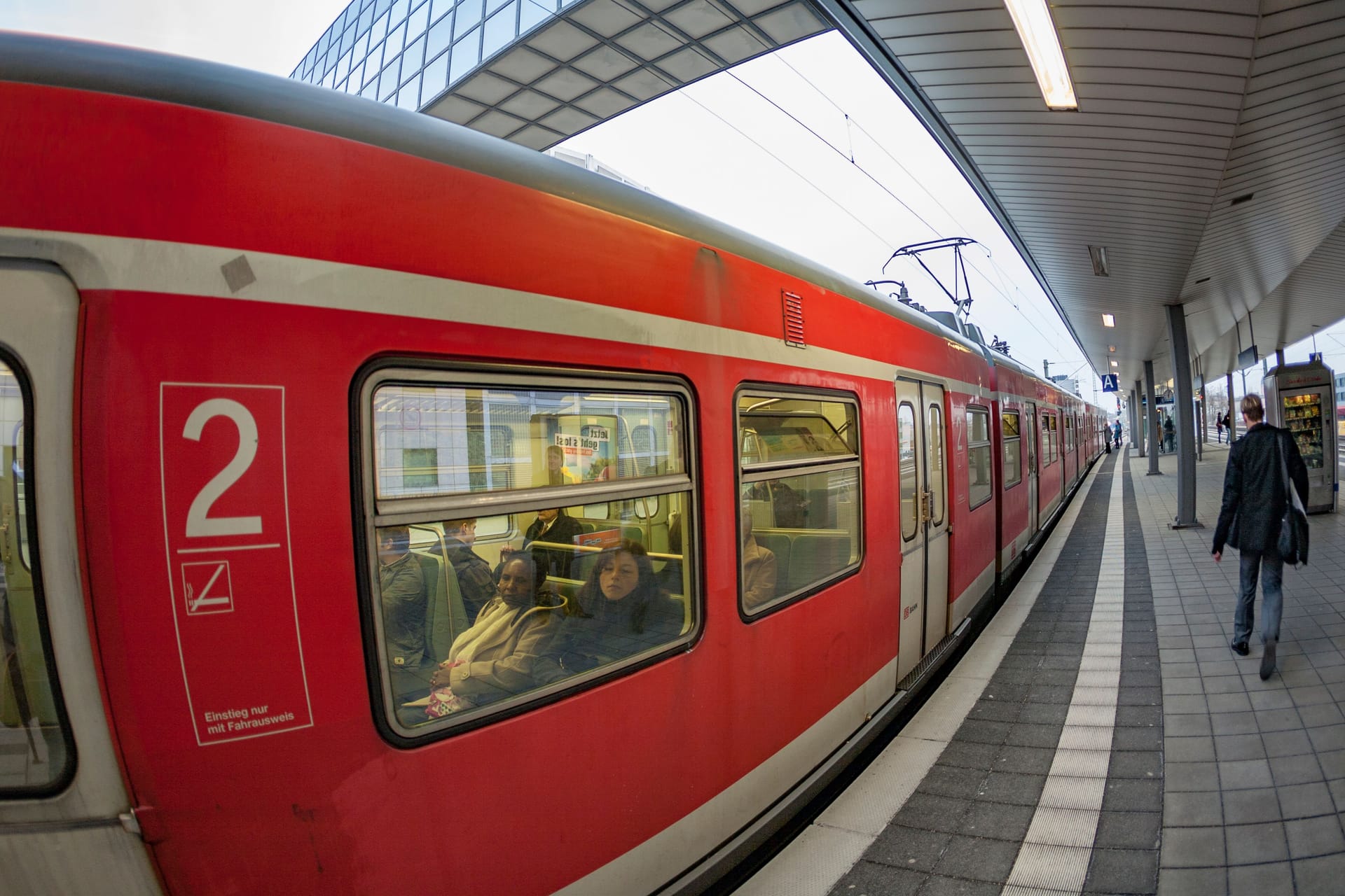 train enters the train station Messe in Frankfurt with view to skyline