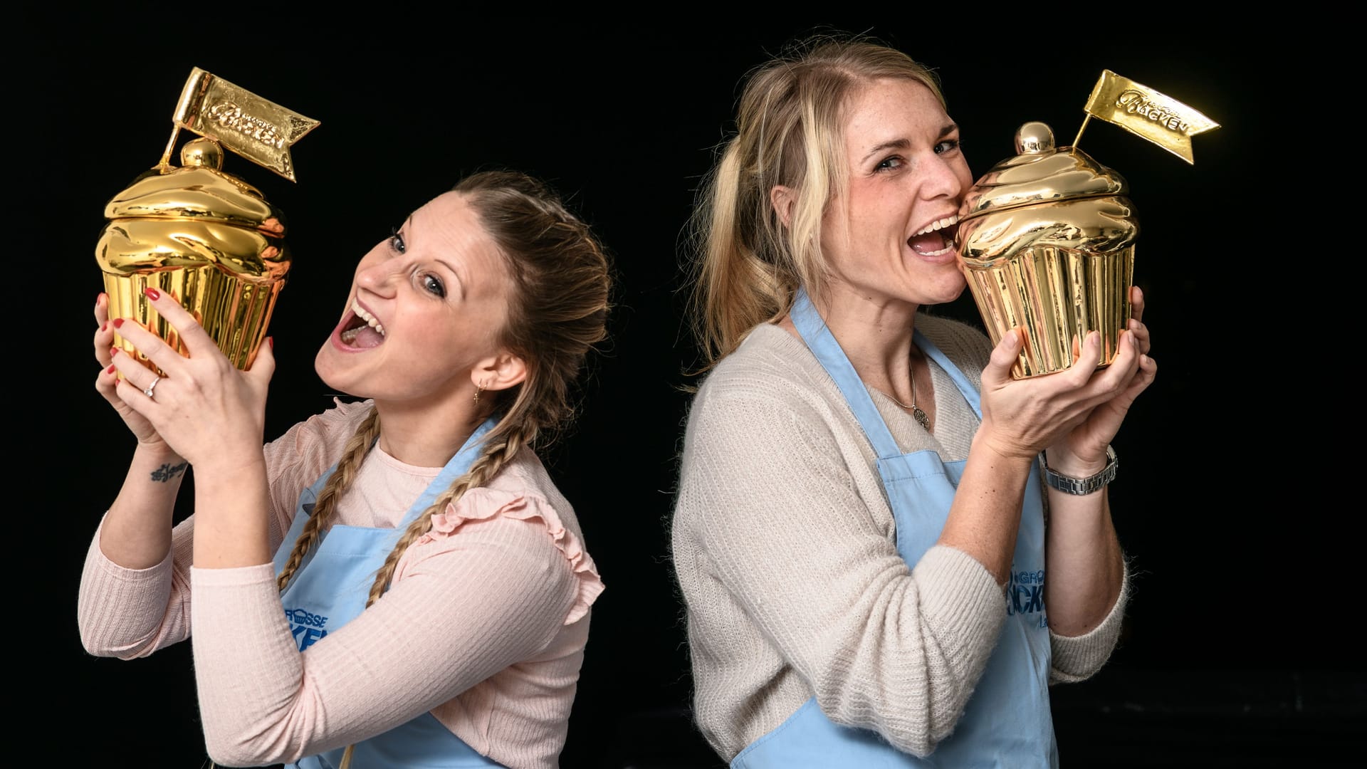 Zwei Siegerinnen einer früheren "Backen"-Staffel: Wer gewinnt, bekommt einen goldenen Cupcake.