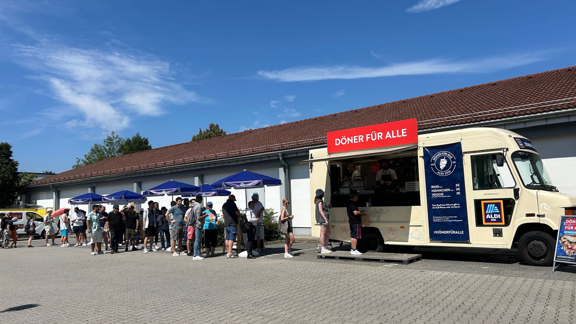 Pralle Hitze am Mittwochmittag: Dutzende Menschen warten vor dem Truck auf ihren Döner.