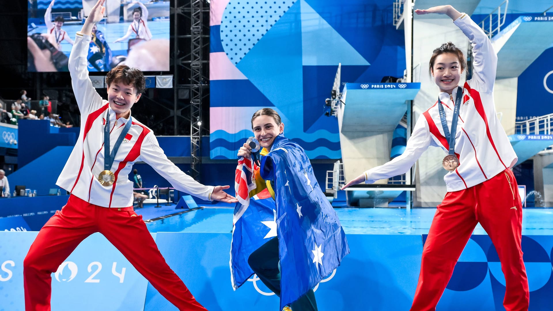 Gemeinsamer Jubel, trotz geopolitischer Spannungen: Die chinesischen Wasserspringerinnen Yiwen Chen (Gold) und Yani Chang (Bronze) feiern mit der australischen Silbermedaillengewinnerin Maddison Keeney.