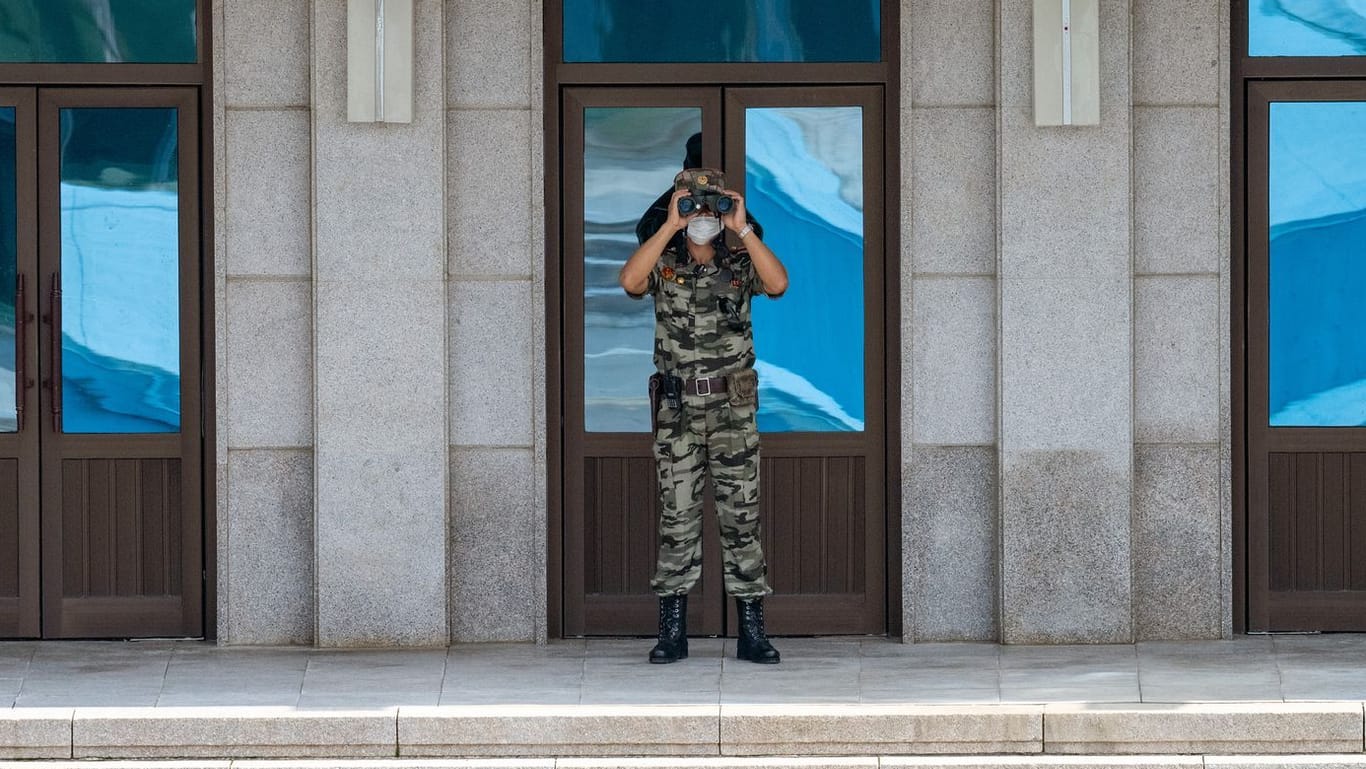 Ein nordkoreanischer Soldat mit Fernglas beobachtet die deutsche Delegation.