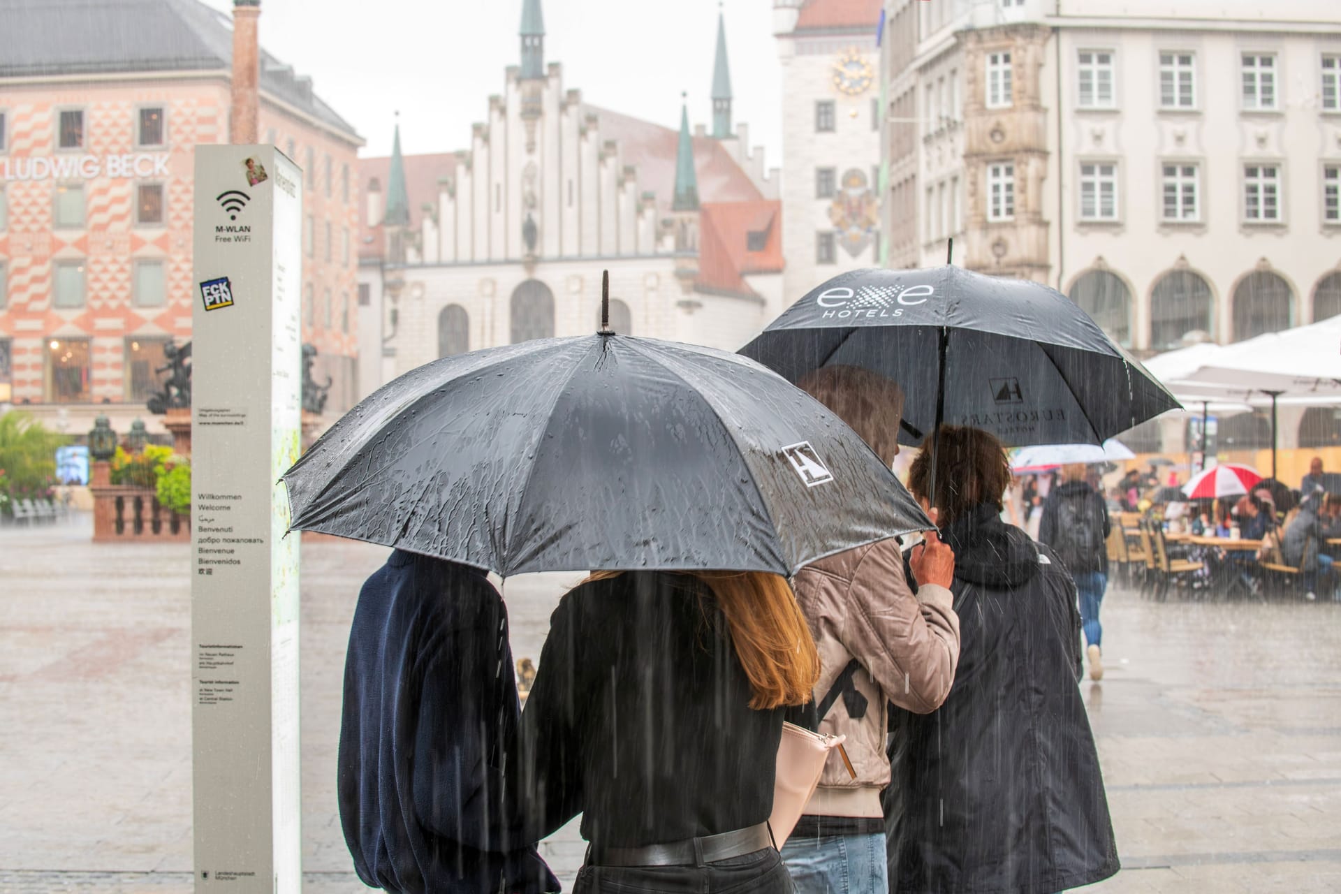 Menschen laufen mit Regenschirmen über den Marienplatz (Archivbild): In München könnte es am Mittwochabend ungemütlich werden.