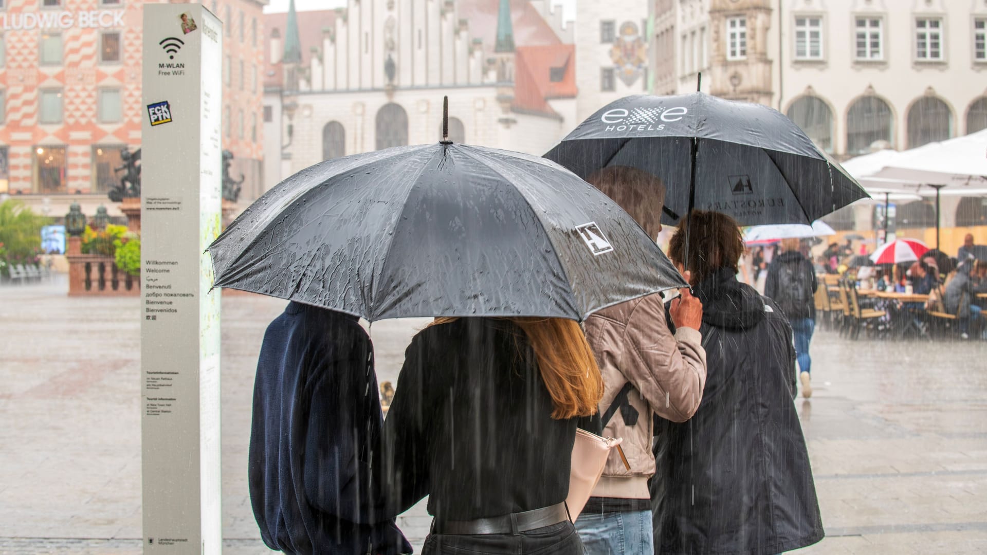 Menschen laufen mit Regenschirmen über den Marienplatz (Archivbild): In München könnte es am Mittwochabend ungemütlich werden.