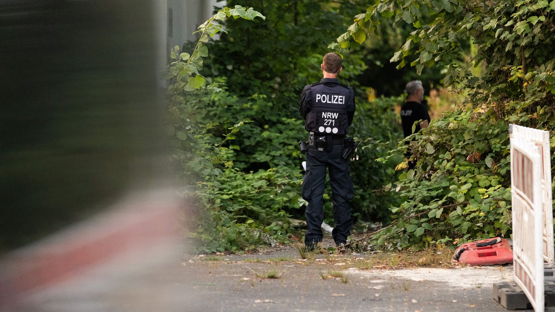 Ein Polizist beim Einsatz in Essen: In diesem Gebüsch hatten Jugendliche den Schädel eines toten Menschen entdeckt.