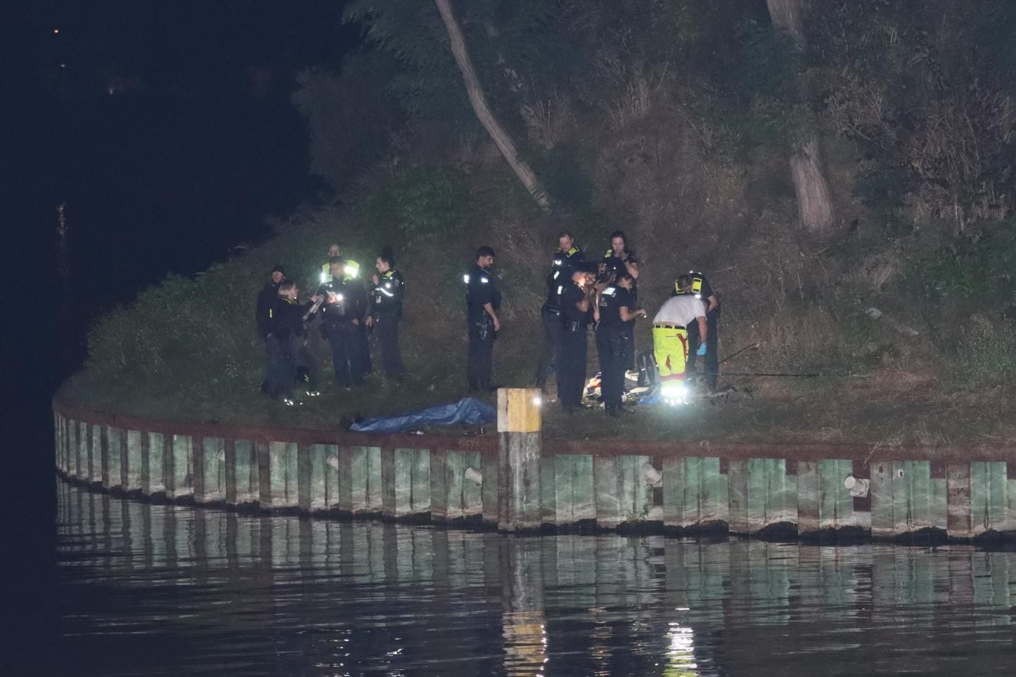 Einsatzkräfte haben den Toten am Westhafenkanal abgedeckt: Er starb in der Nacht zu Montag, nachdem er ins Wasser gefallen ist.