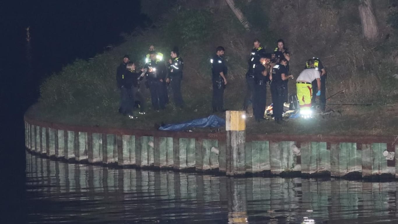 Einsatzkräfte haben den Toten am Westhafenkanal abgedeckt: Er starb in der Nacht zu Montag, nachdem er ins Wasser gefallen ist.