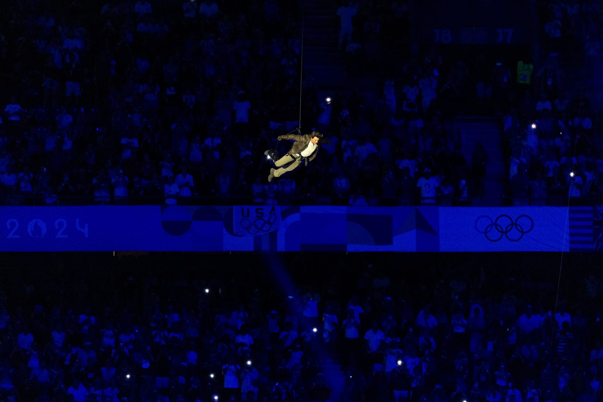 Niemand Geringeres als Hollywood-Star Tom Cruise ließ sich bei der Abschlussfeier vom Dach des Stade de France abseilen, um die olympische Flagge für die Spiele 2028 in Los Angeles entgegenzunehmen.