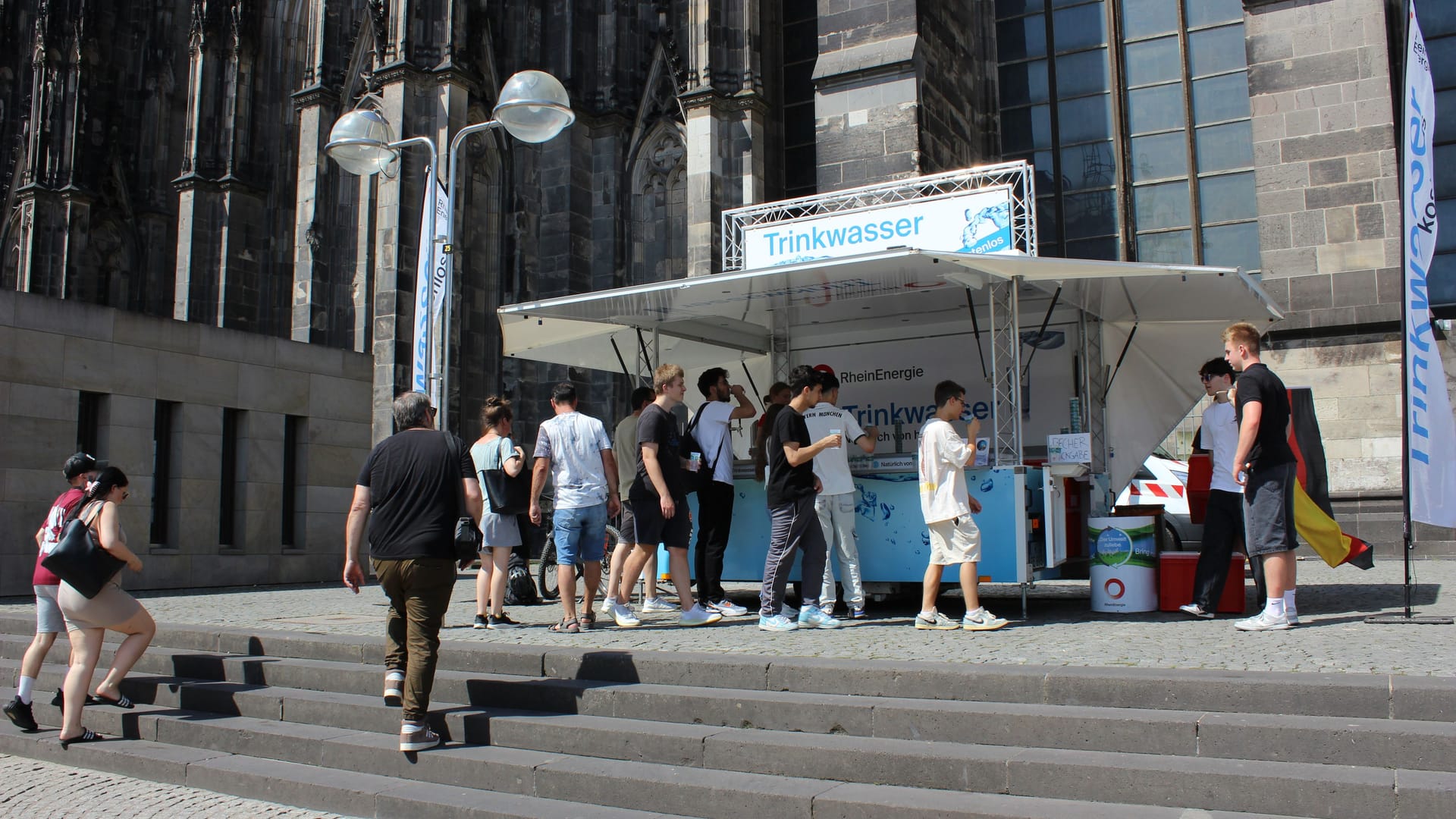 Roncalliplatz: An einem Getränkestand wird kostenlos Leitungswasser verteilt.