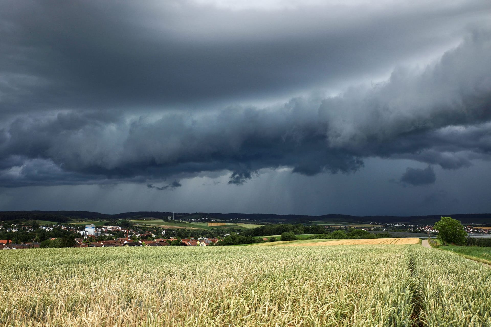 Eine Gewitterzelle mit dunklen Wolken baut sich am Himmel auf