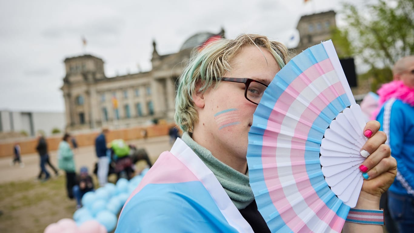 Amity hält einen Fächer in den Transgender-Farben