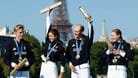 Tim Hellwig, Lisa Tertsch, Lasse Luehrs und Laura Lindemann feiern auf dem Podium ihre Goldmedaille in der Triathlon-Mixed-Staffel.