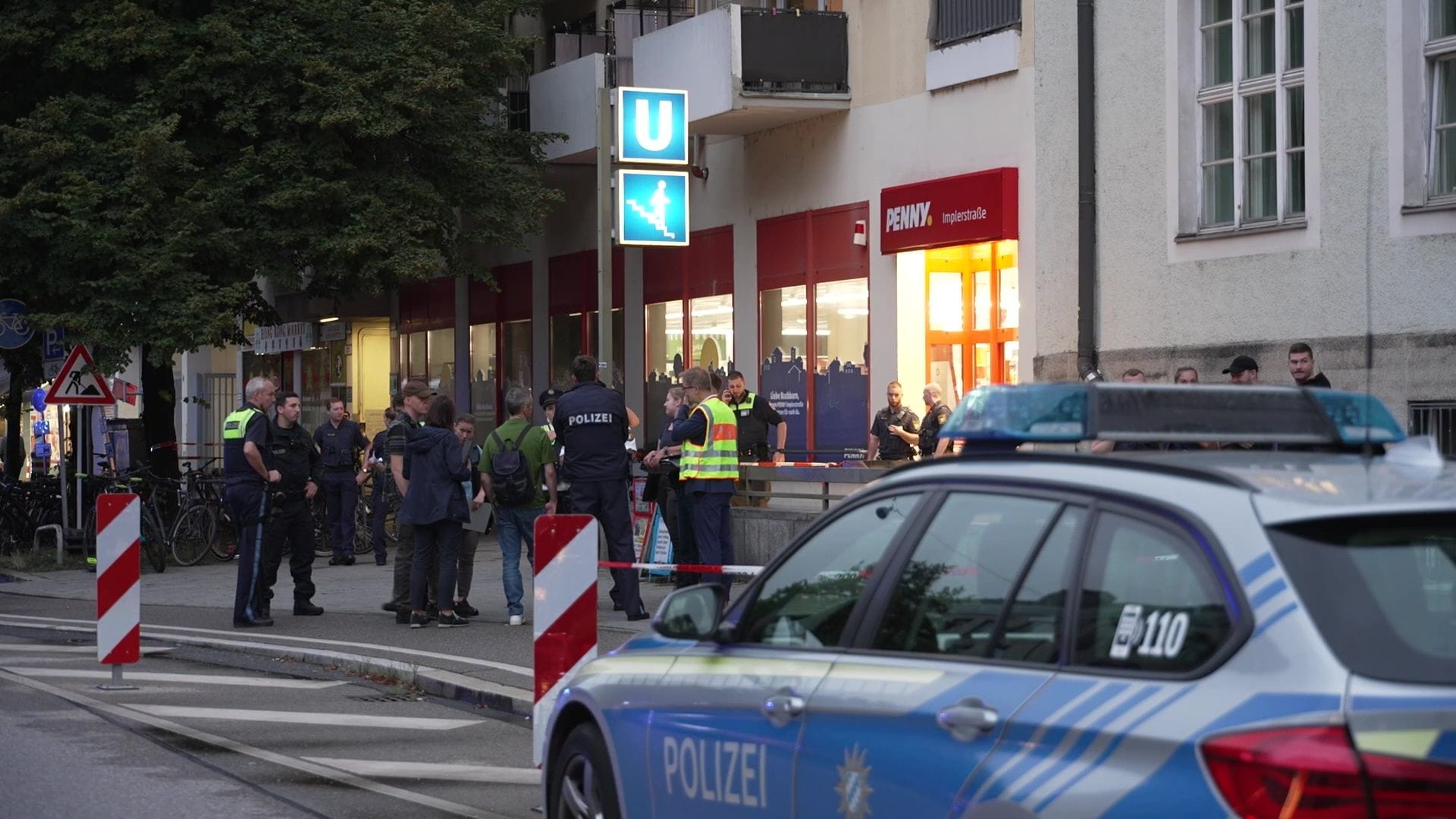 Ein Streifenwagen und Polizisten vor dem Penny-Markt in der Implerstraße am Montagabend: Eine Frau soll hier Beamte attackiert haben.