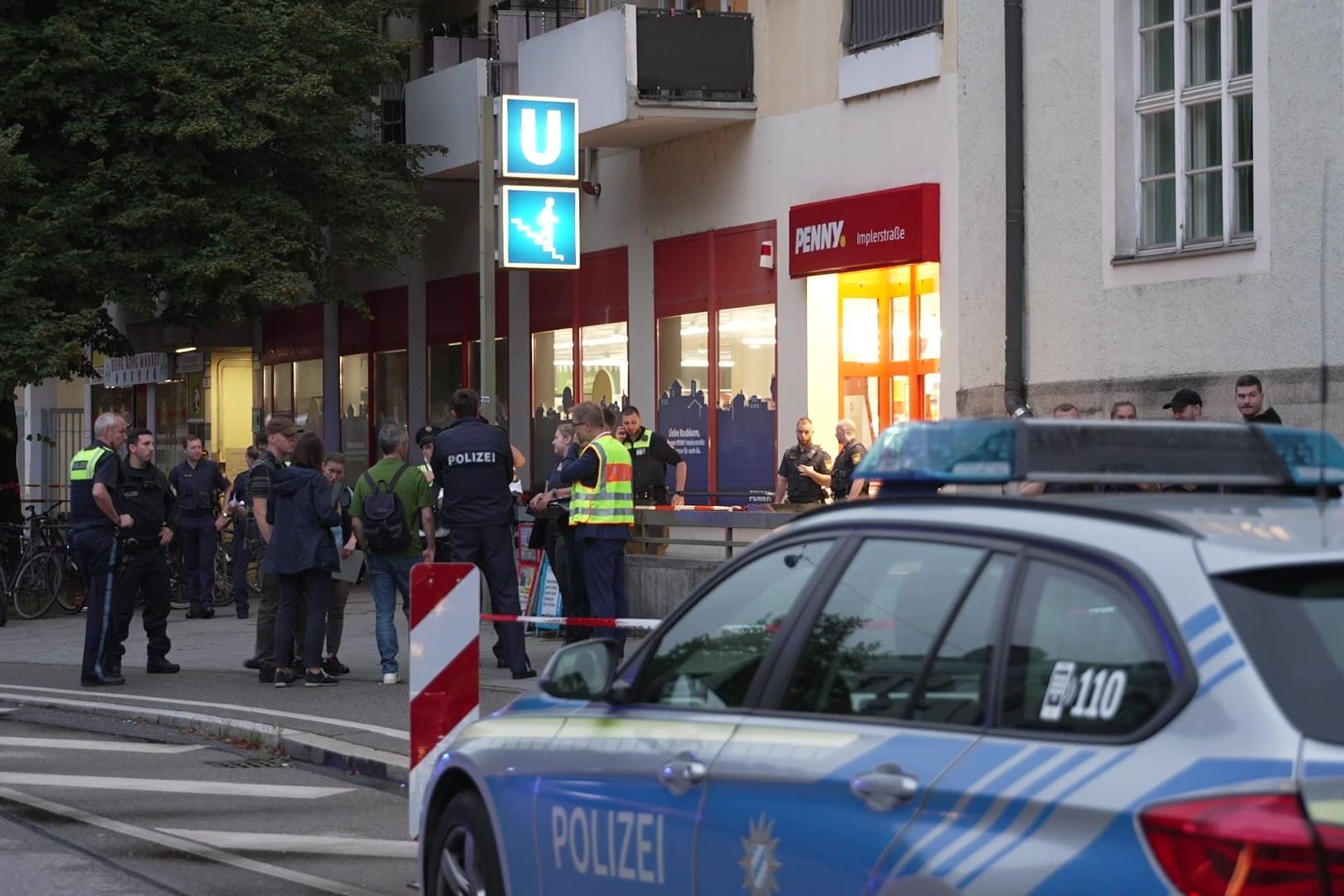 Ein Streifenwagen und Polizisten vor dem Penny-Markt in der Implerstraße am Montagabend: Eine Frau soll hier Beamte attackiert haben.