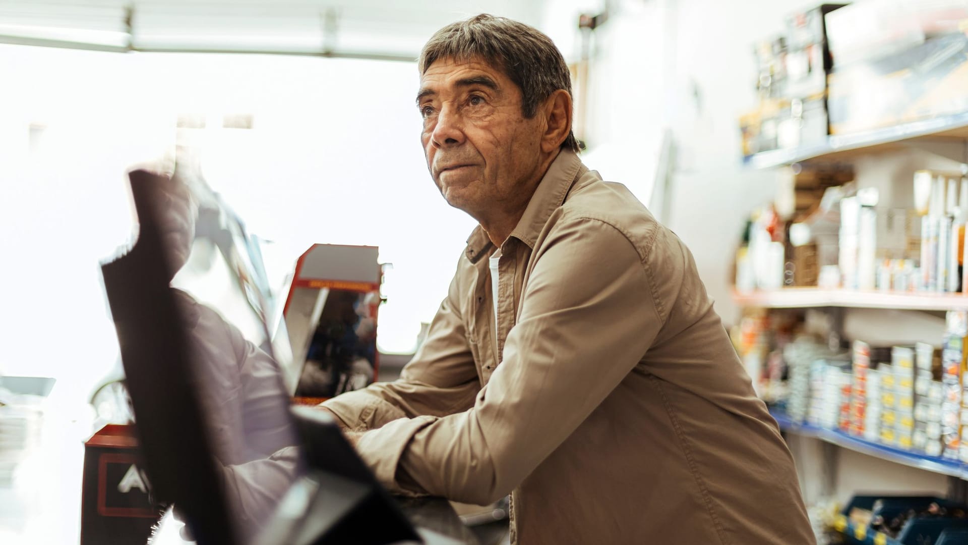 Älterer Mann arbeitet in einem Kiosk: Etwa 7 Prozent der Altersrentner arbeiten auch im Ruhestand weiter, ein Großteil davon in einem Minijob.