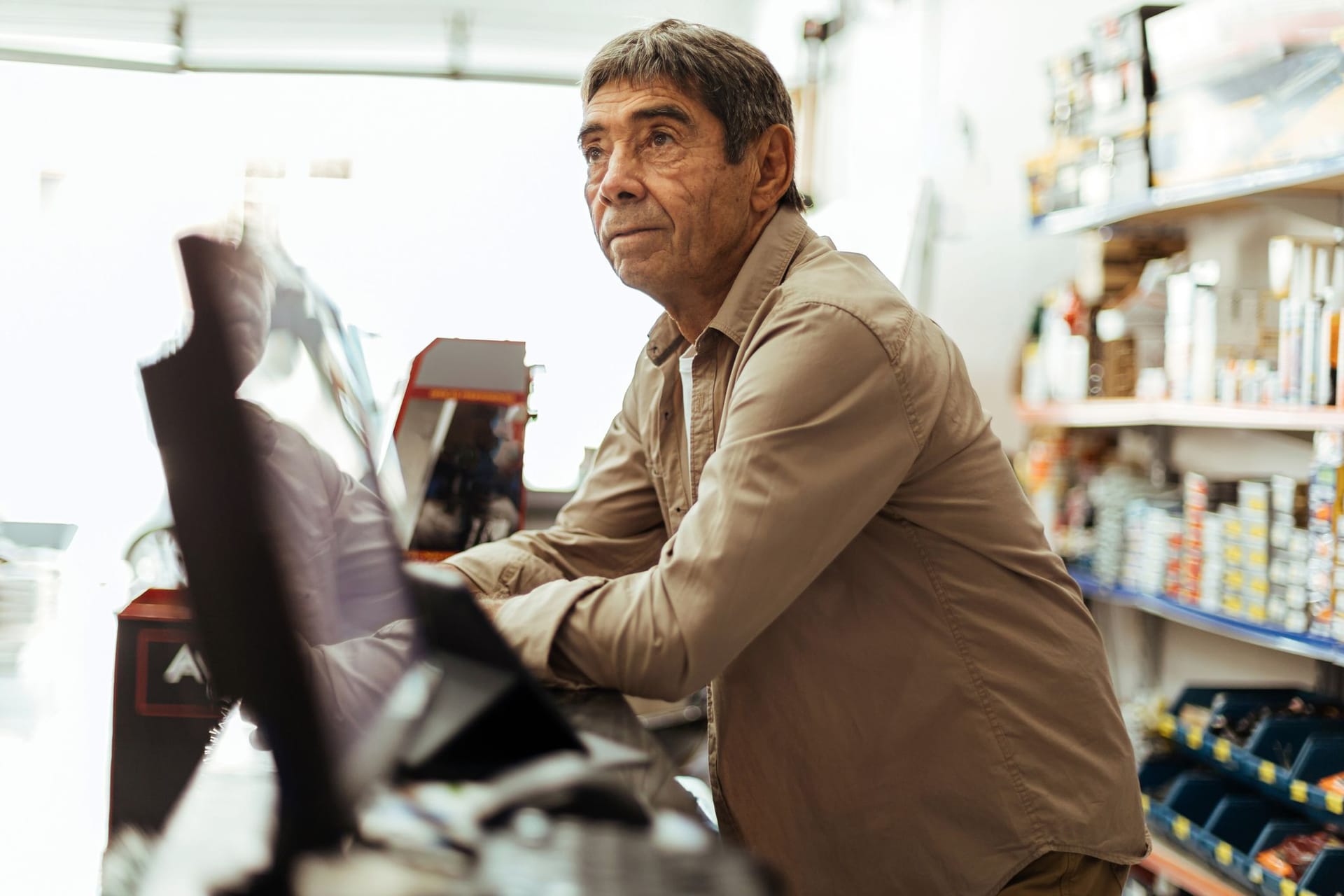 Älterer Mann arbeitet in einem Kiosk: Etwa 7 Prozent der Altersrentner arbeiten auch im Ruhestand weiter, ein Großteil davon in einem Minijob.