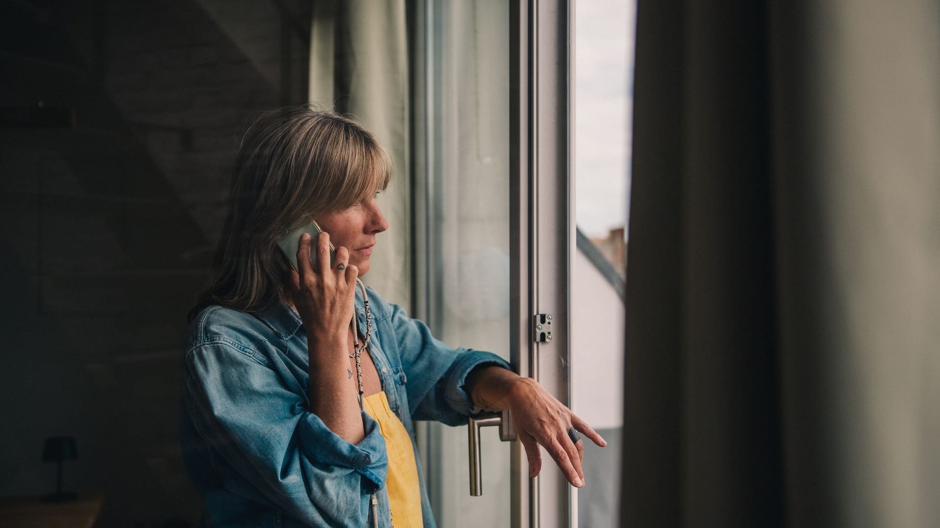 Eine Frau telefoniert am Fenster