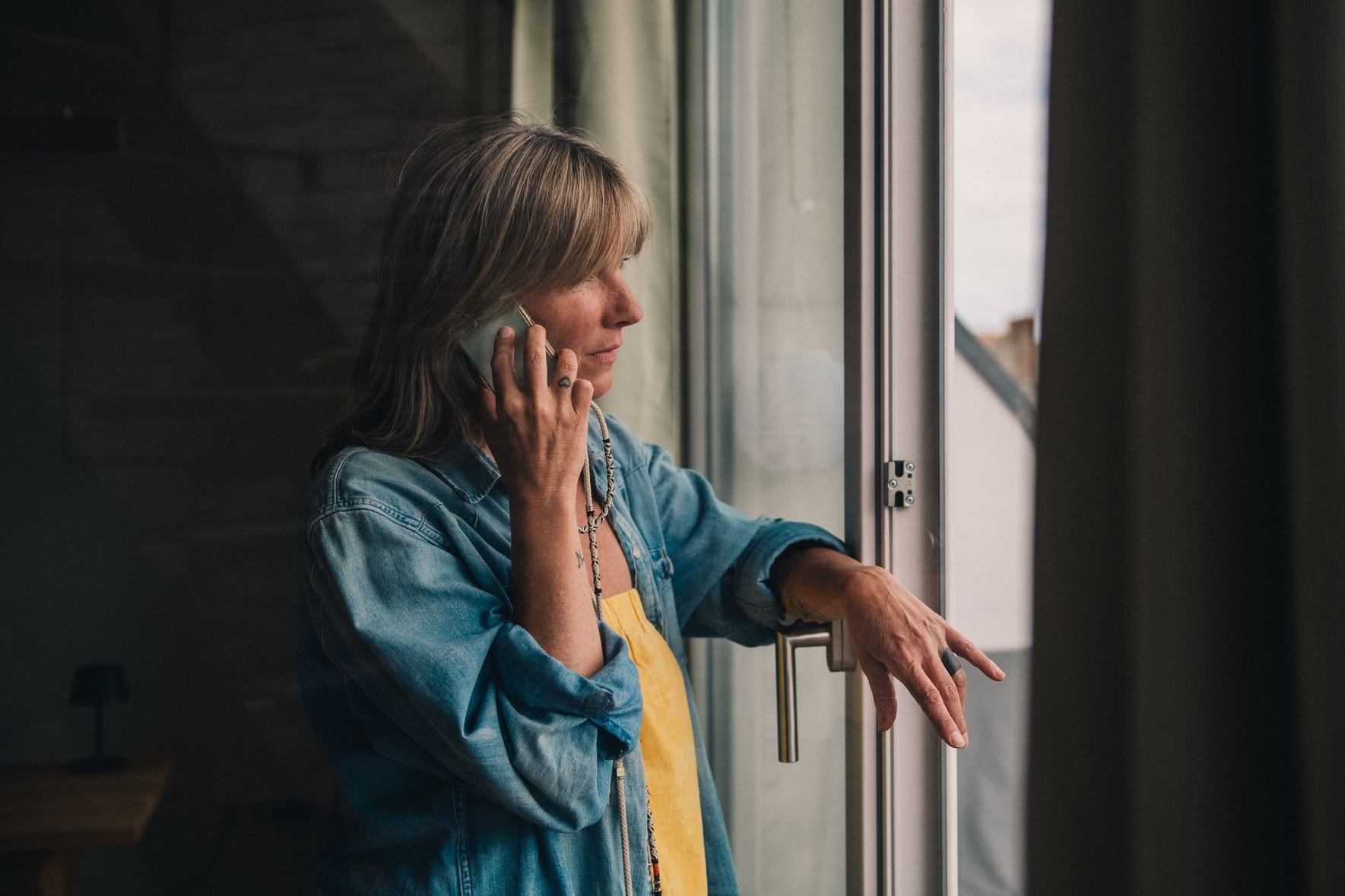 Eine Frau telefoniert am Fenster