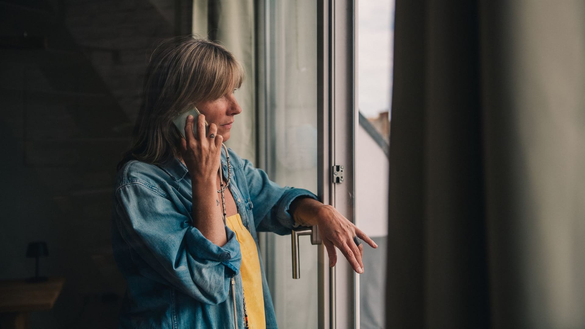 Eine Frau telefoniert am Fenster