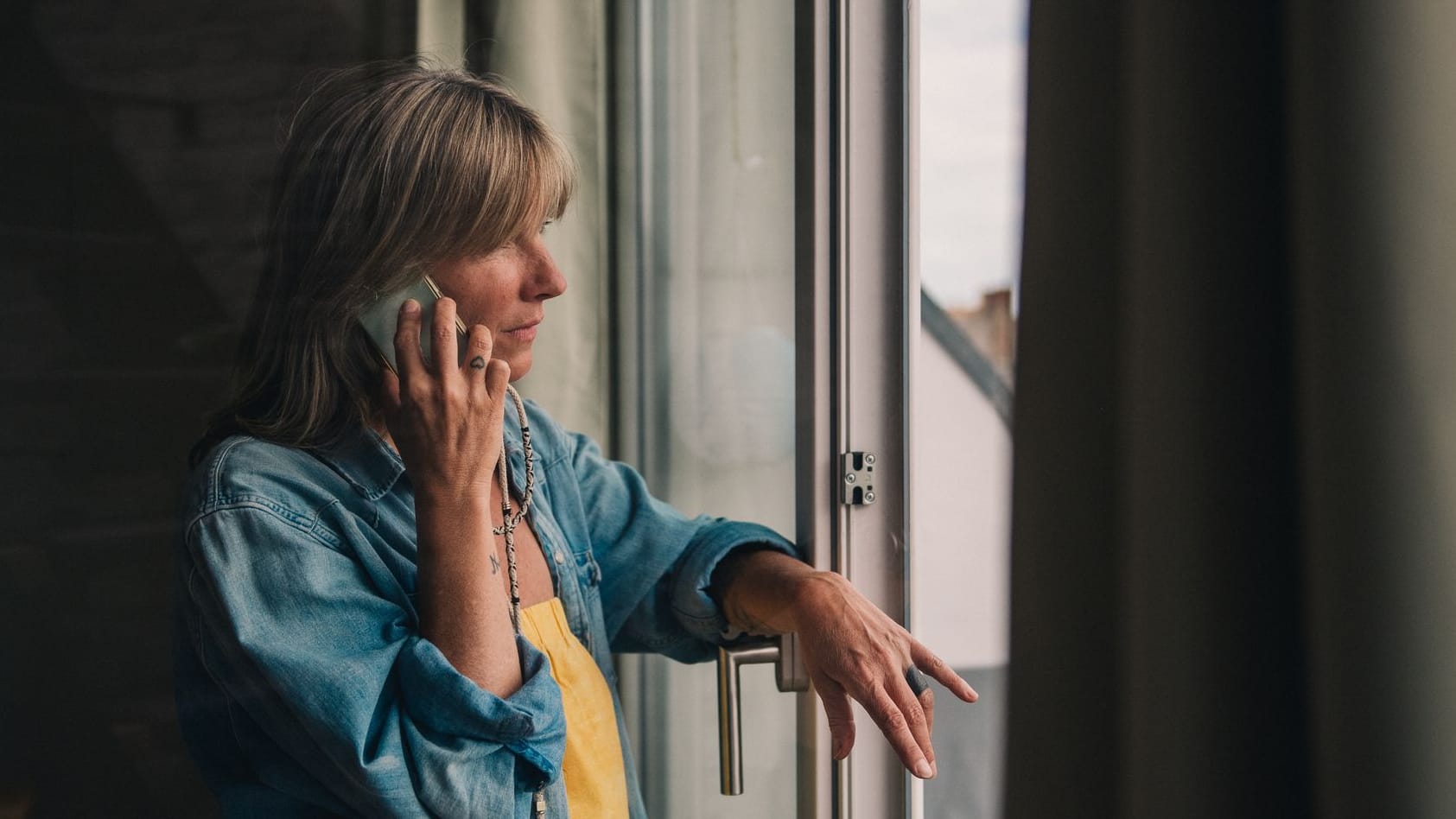Eine Frau telefoniert am Fenster Eine Frau telefoniert am Fenster