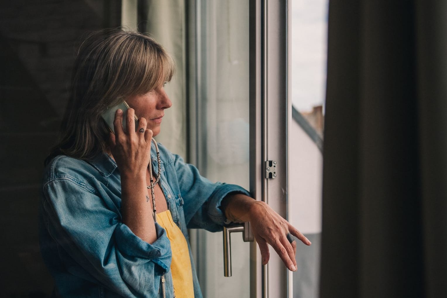 Eine Frau telefoniert am Fenster