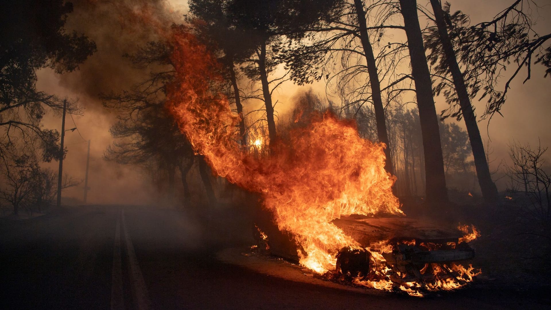 Ein Auto brennt während eines Waldbrandes im Dorf Varnava.