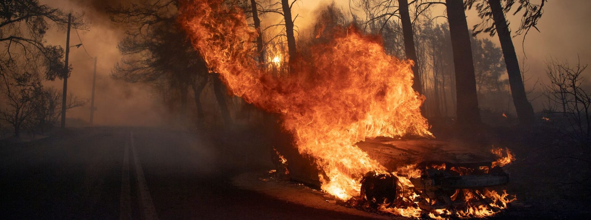 Ein Auto brennt während eines Waldbrandes im Dorf Varnava.