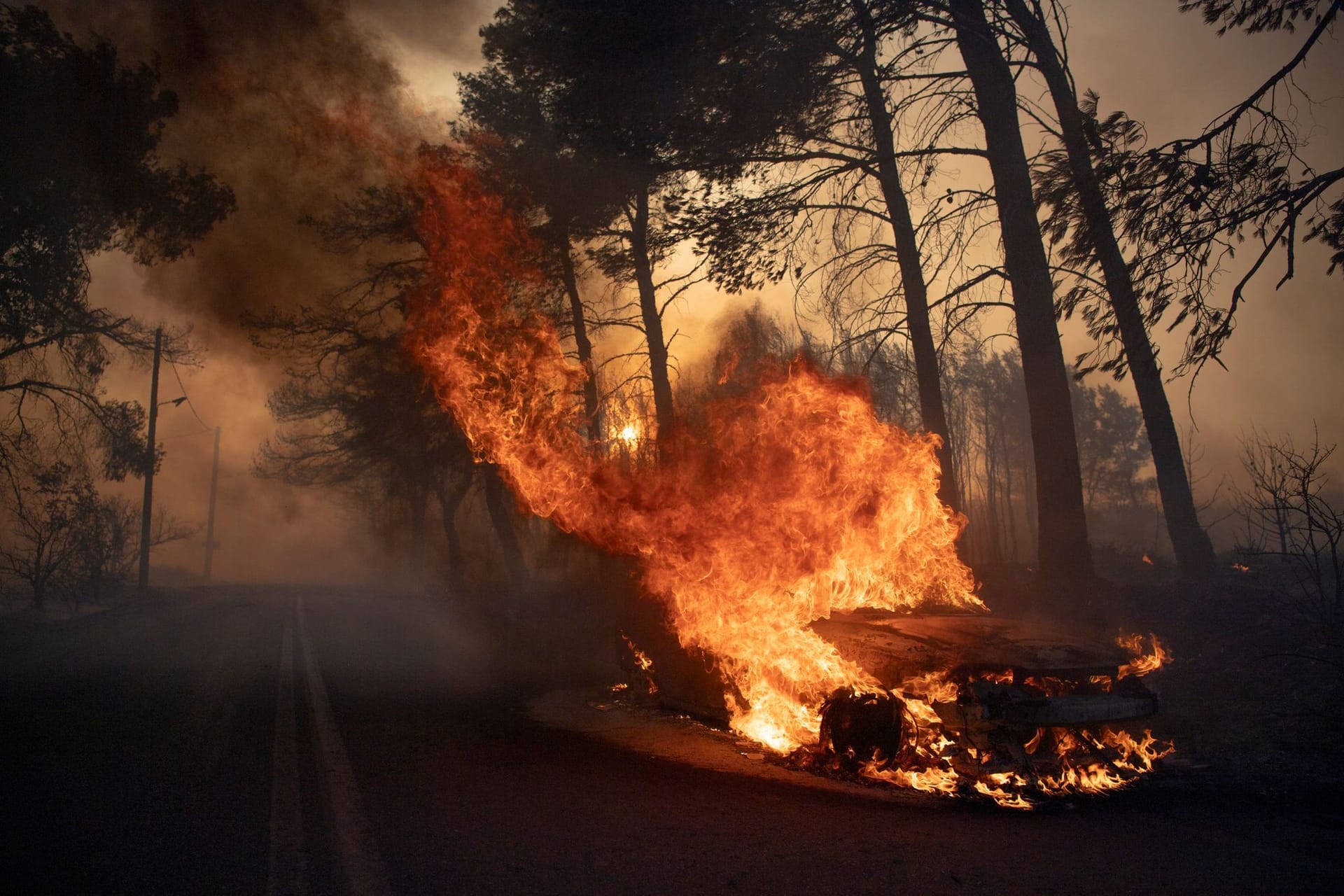 Ein Auto brennt während eines Waldbrandes im Dorf Varnava.