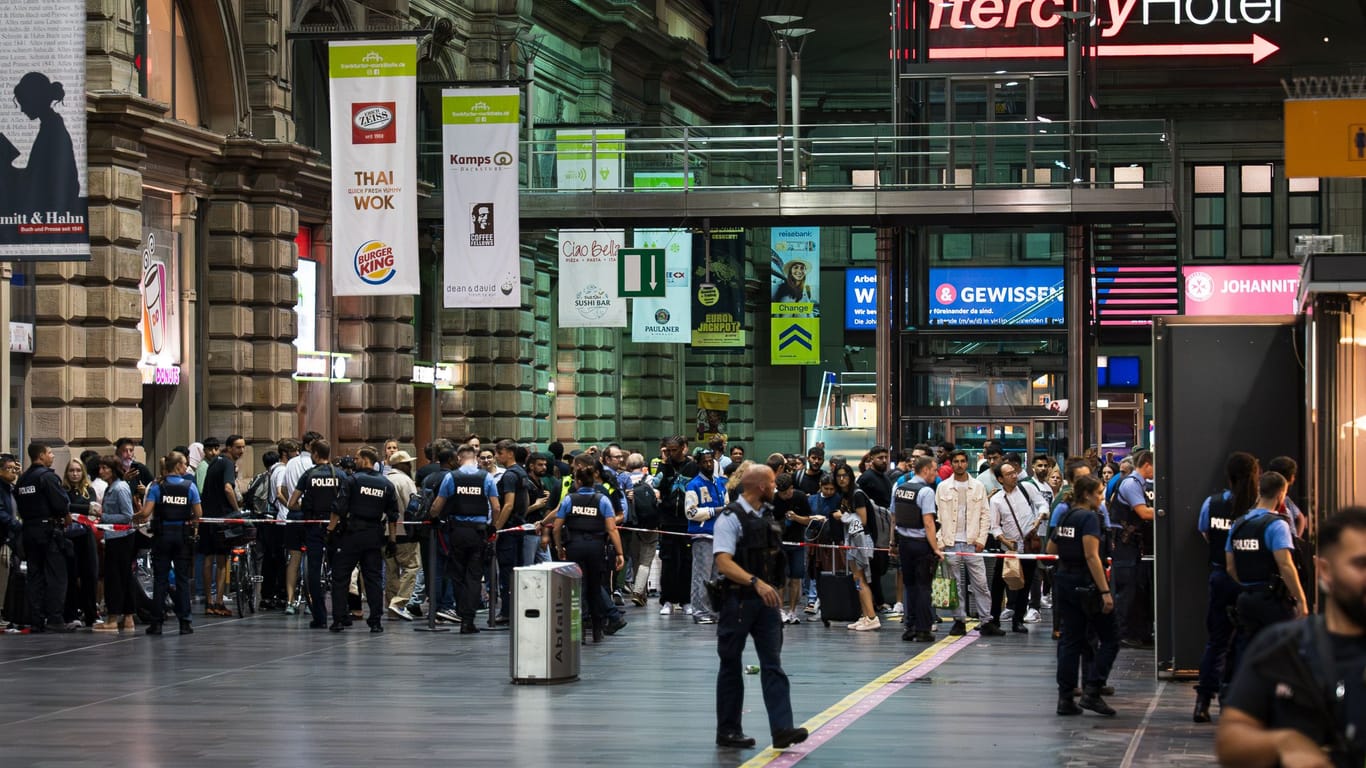 Reisende und Passanten müssen hinter einem Absperrband warten. Zeitweise wurde der Hauptbahnhof komplett gesperrt.