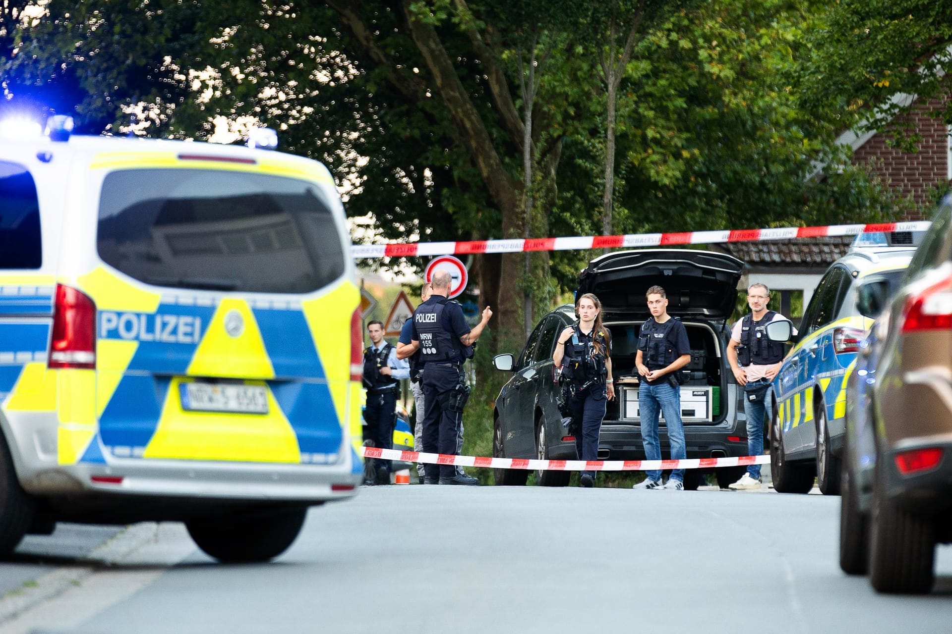 Recklinghausen: Einsatzkräfte der Polizei stehen an einem Tatort zwischen Fahrzeugen.