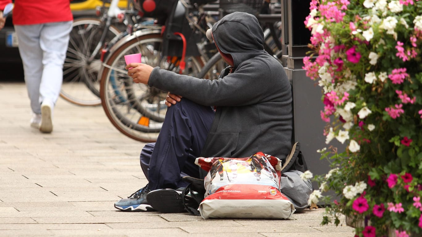 Eine obdachlose Person sitzt auf der Straße (Archivbild): Der Hamburger Kältebus verteilt kostenloses Wasser gegen die Hitze.