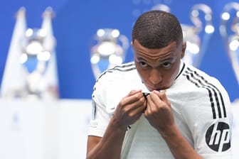 Kylian Mbappé küsst das Wappen von Real Madrid: Schon in seinem ersten Spiel für die "Königlichen" winkt dem Franzosen ein Titel.