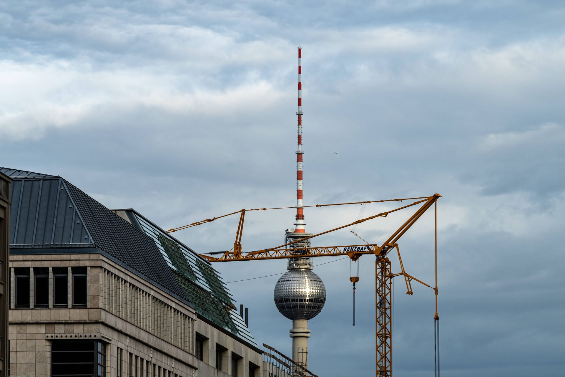 Baukran vor dem Fernsehturm (Symbolbild): Geflüchtete bekommen ab September weniger Bürgergeld ausgezahlt.