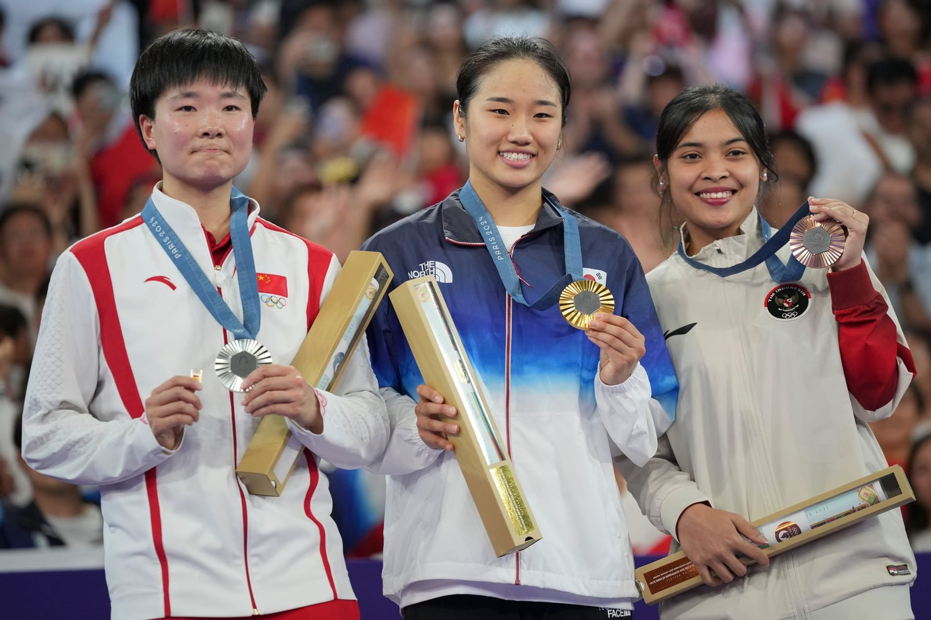 Emotionale Szene im Badminton: He Bingjiao (l.) erinnerte mit einem Pin bei der Zeremonie an ihre Halbfinal-Gegnerin, die sich das Kreuzband riss.