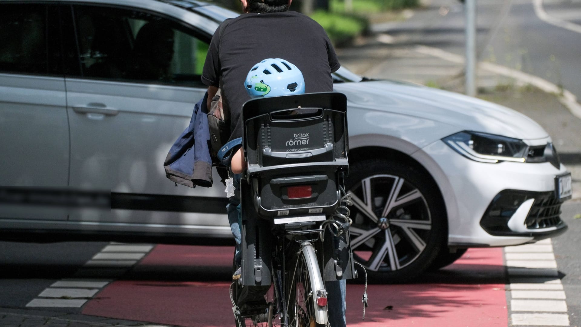 Fahrrad mit Kindersitz: Das Kind trägt einen Helm