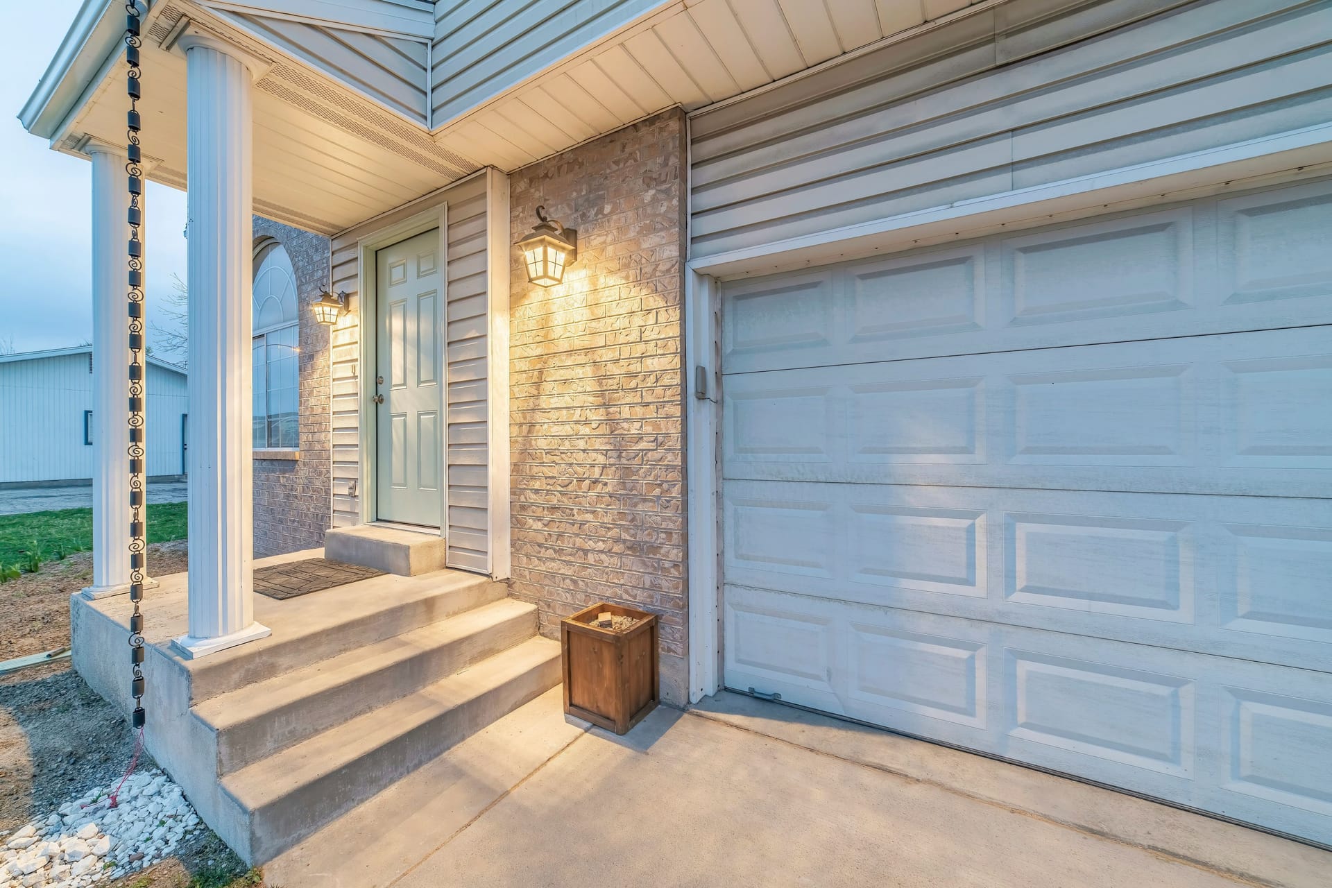 Exterior of a house with stone veneer siding and sectional garage door