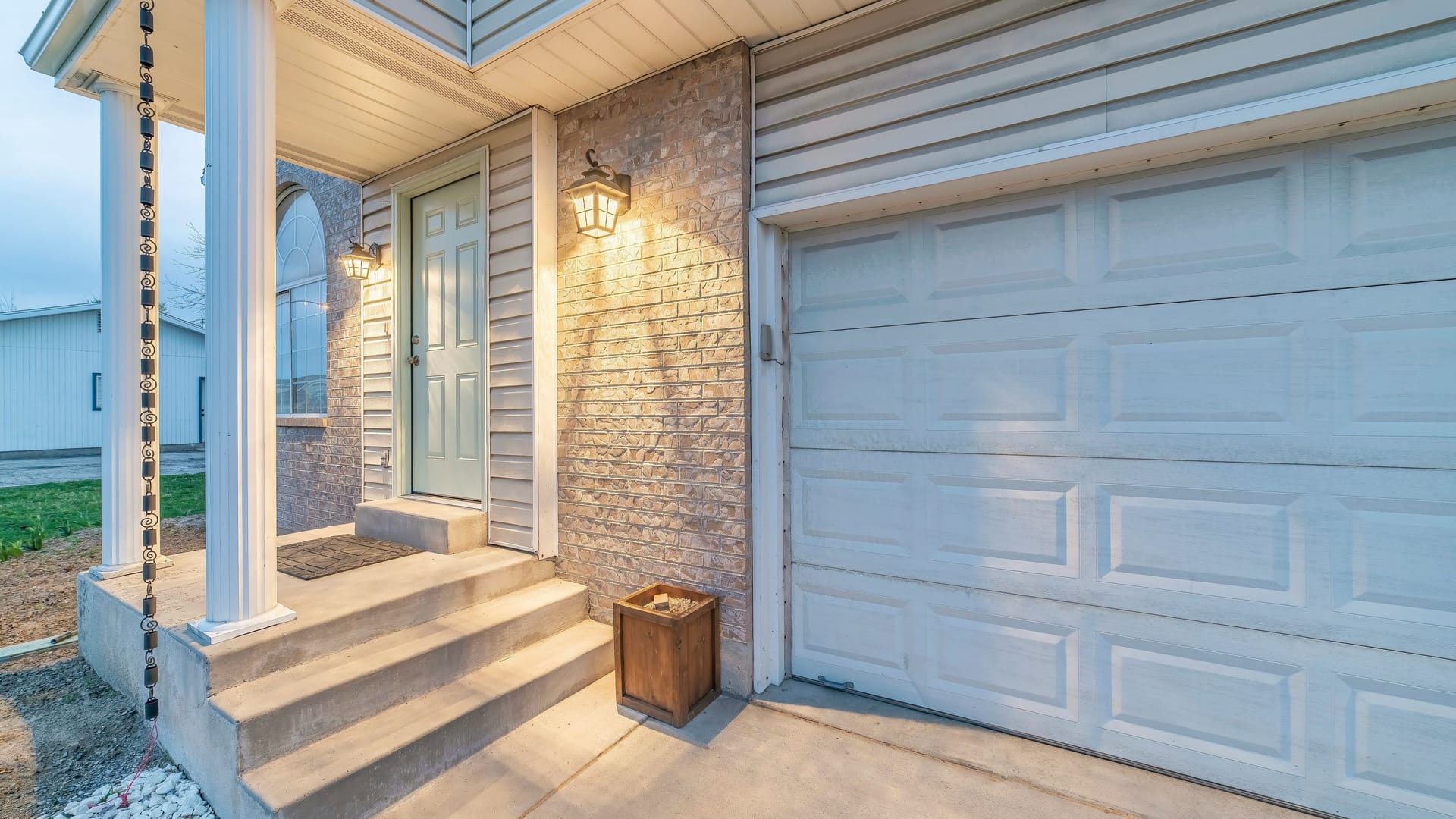 Exterior of a house with stone veneer siding and sectional garage door