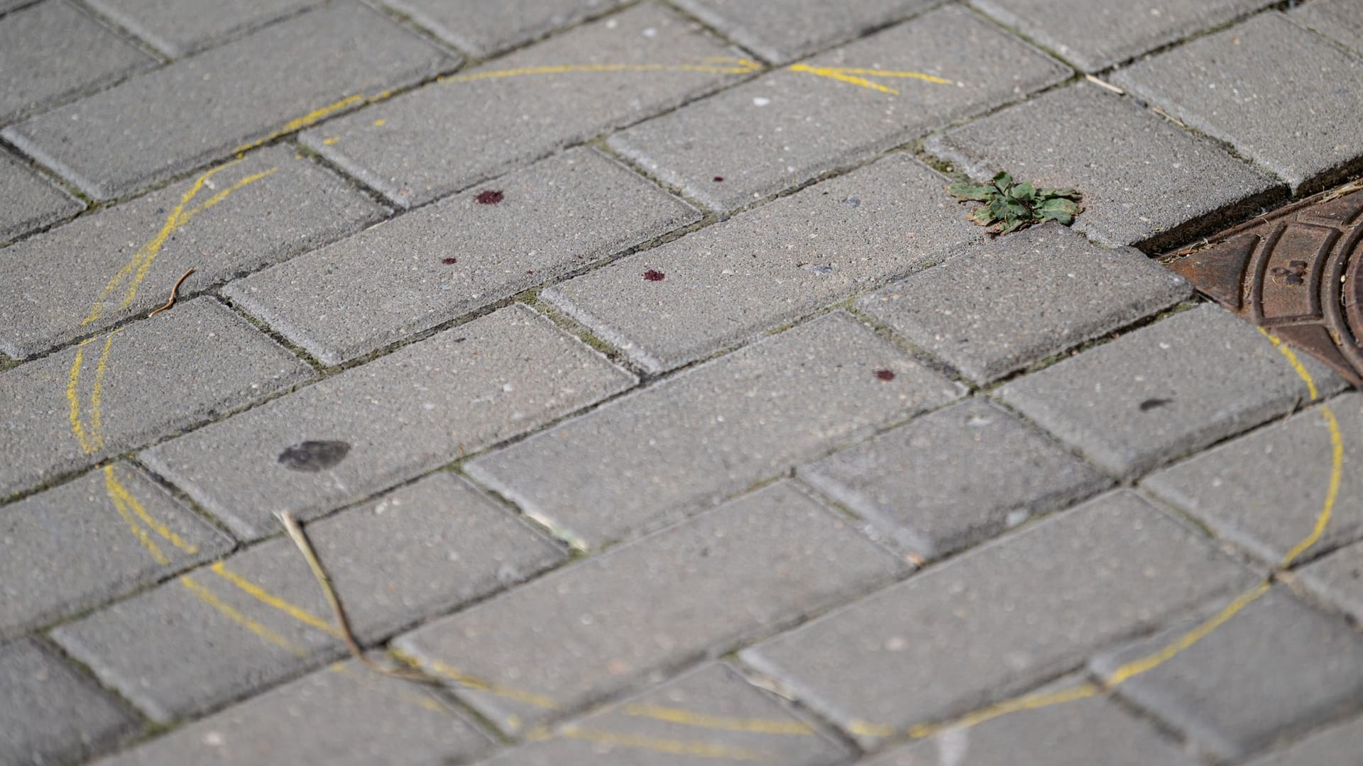 Mit einem gelben Kreis markierte Blutstropfen sind nach einem tödlichen Messerangriff auf dem Boden vor einem Hauseingang in Berlin-Friedrichsfelde zu sehen.