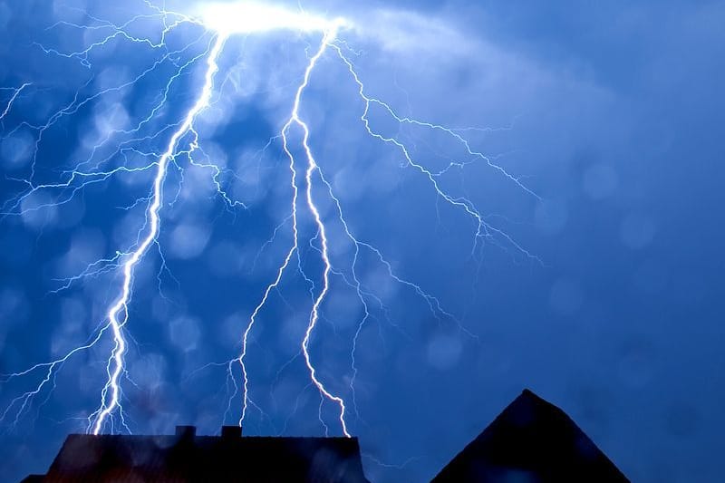 Ein Blitz schlägt in ein Hausdach ein (Symbolbild): In Würselen ist so ein Dachstuhl in Brand geraten.