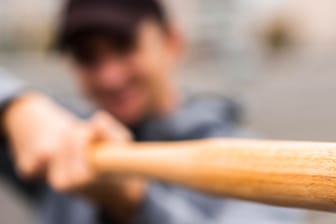 Eine Person hält einen Baseballschläger (Symbolbild): Ein 20-Jähriger wurde am Sonntag brutal verprügelt.