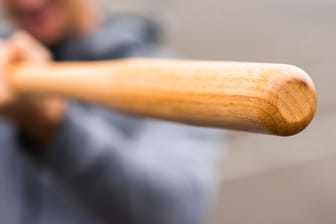 Eine Person hält einen Baseballschläger (Symbolbild): Ein 20-Jähriger wurde am Sonntag brutal verprügelt.