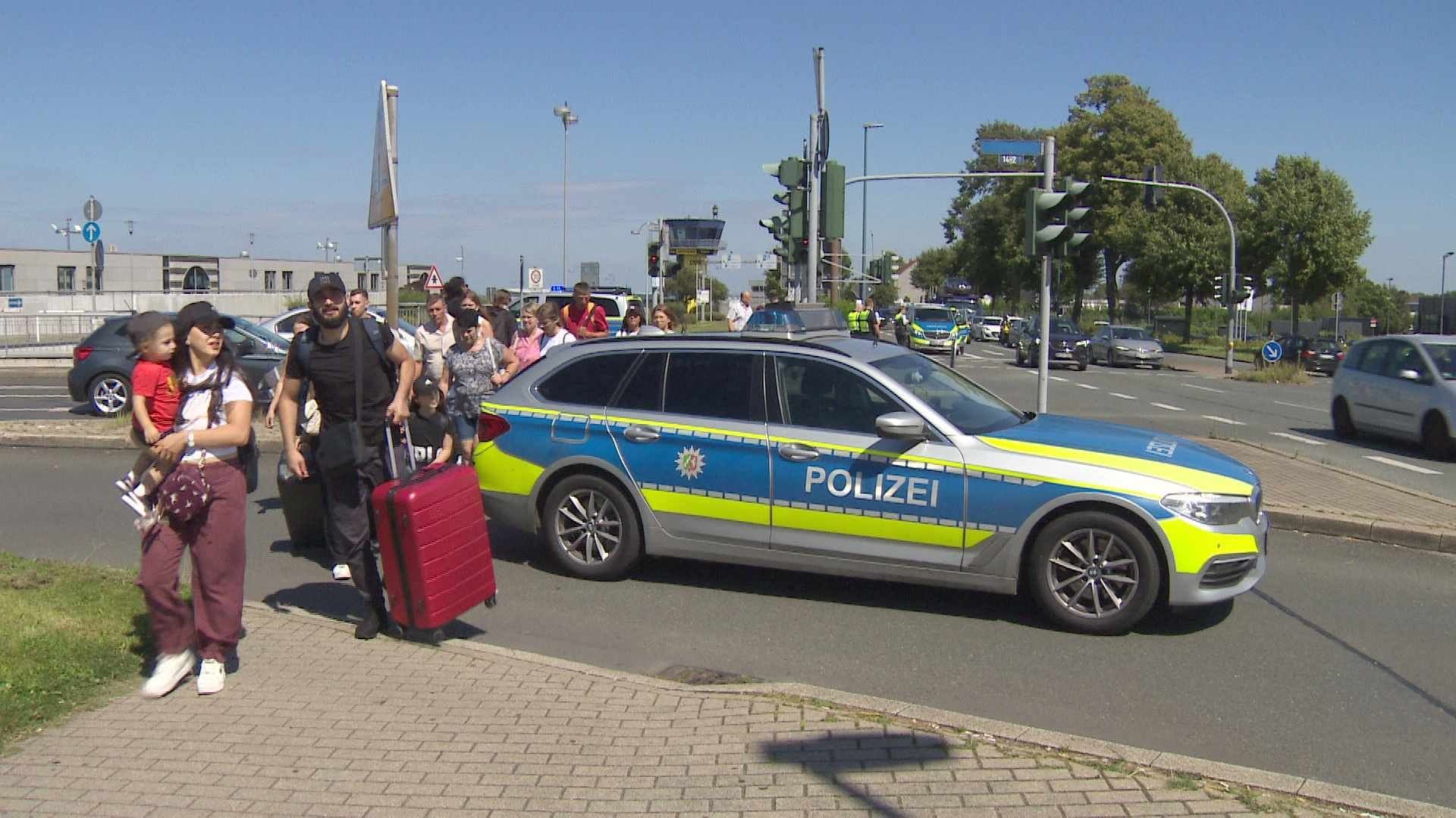 Die Polizei hat die Zufahrt zum Flughafen und den dazugehörigen Parkhäusern versperrt: Reisende machten sich zu Fuß auf den Weg zum Terminal.