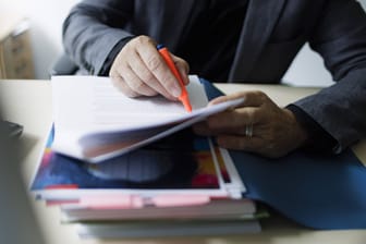 Mitarbeiter bearbeitet Akten (Symbolbild): Beim Finanzamt sammeln sich viele persönliche Informationen.